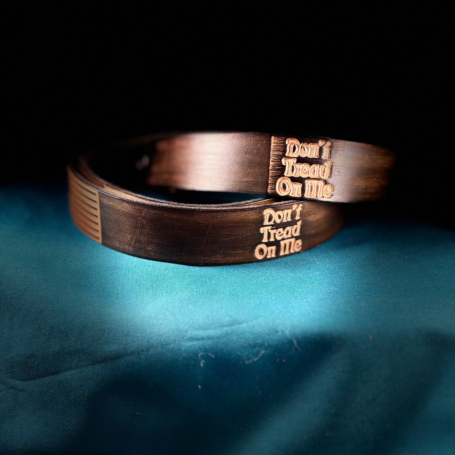 Bronze bracelet with 'Don't Tread On Me' engraving on a dark background
