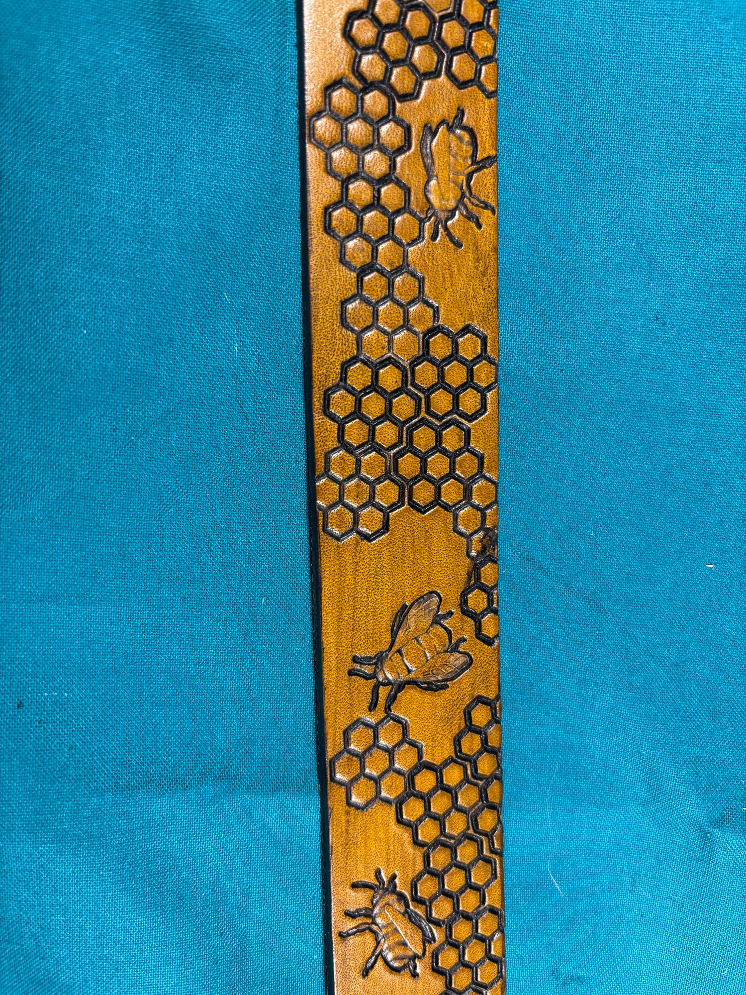Wooden strip with honeycomb and bee design on a blue background