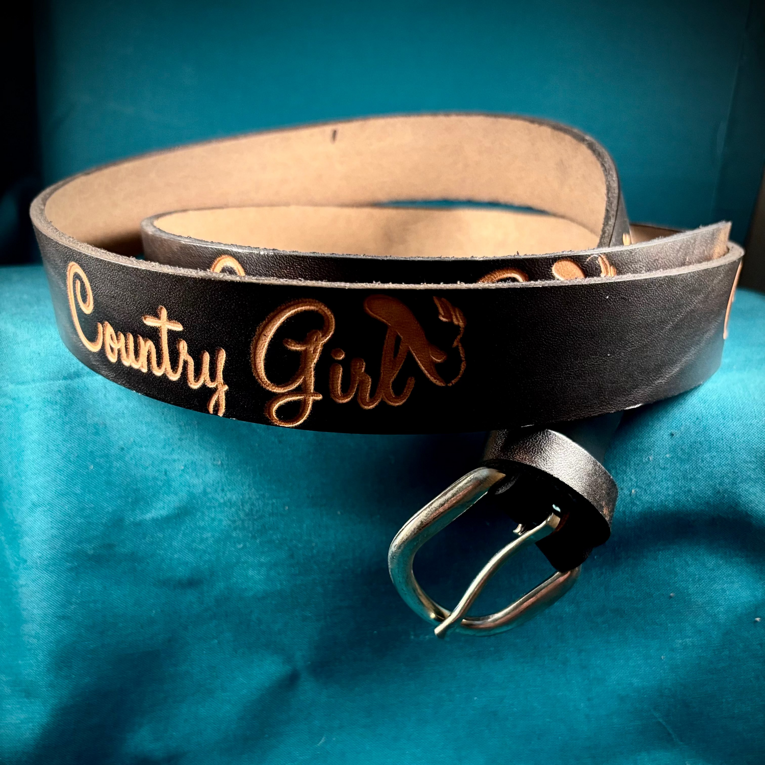 Black leather belt with 'Country Girl' engraving on a blue background