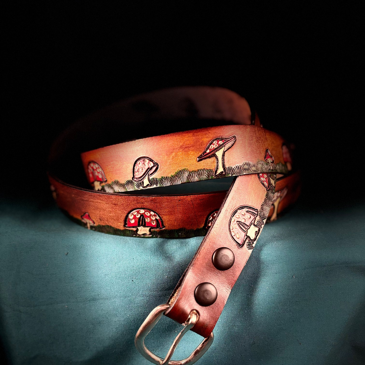 Brown leather belt with decorative elements on a dark background