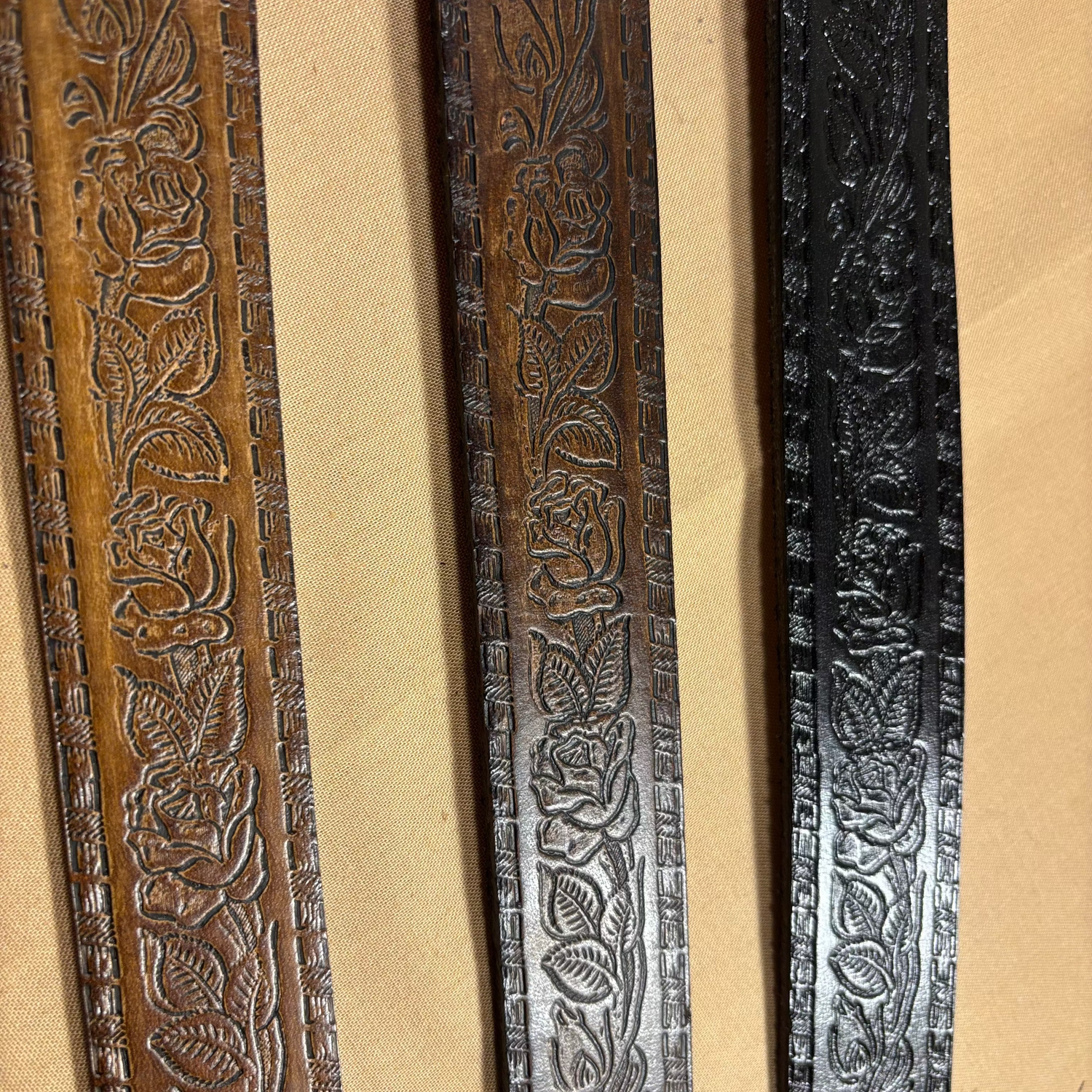 Three wooden frames with intricate carvings on a beige background