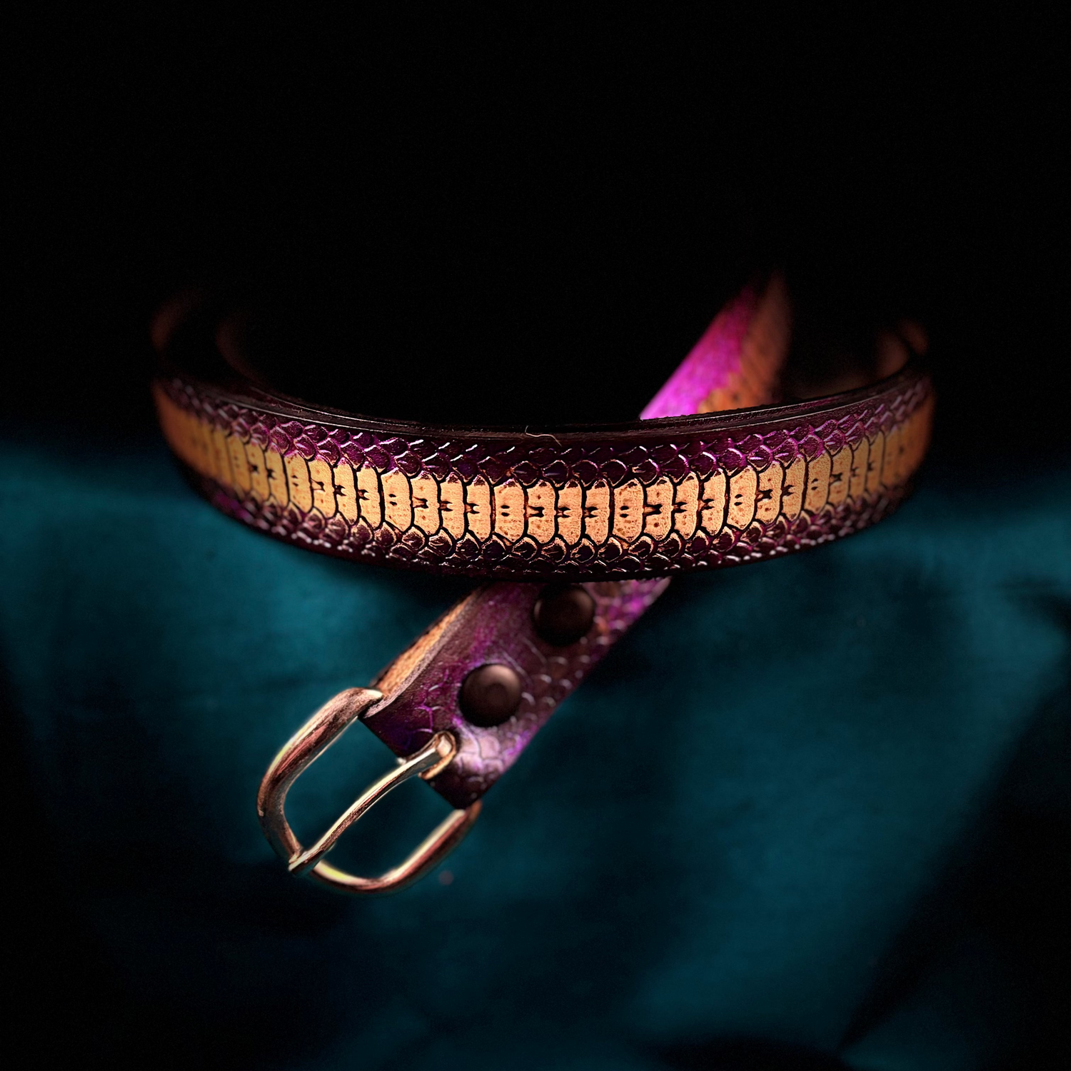 Purple leather belt with gold accents on a dark background